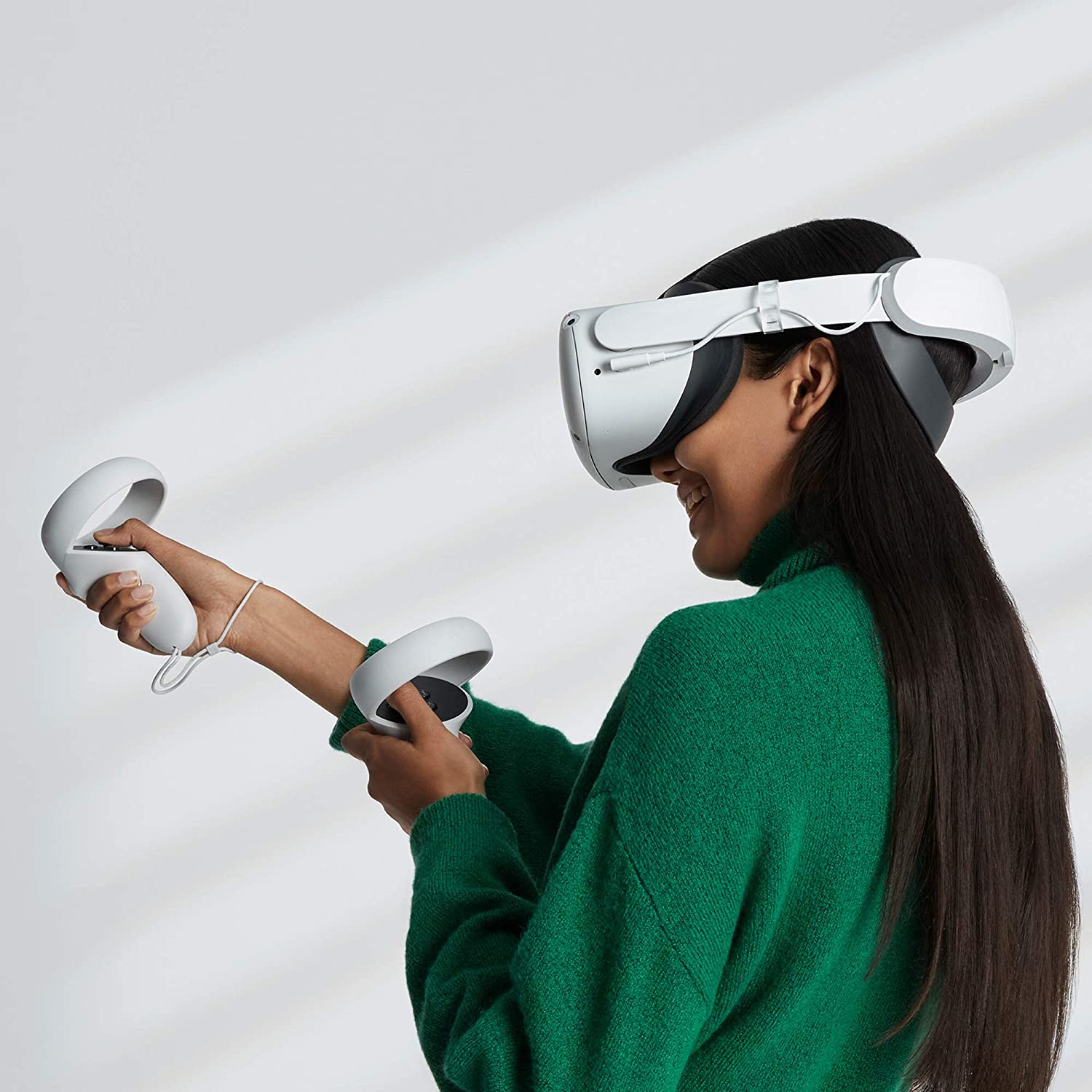 model in a green sweater  playing with  Oculus Quest 2